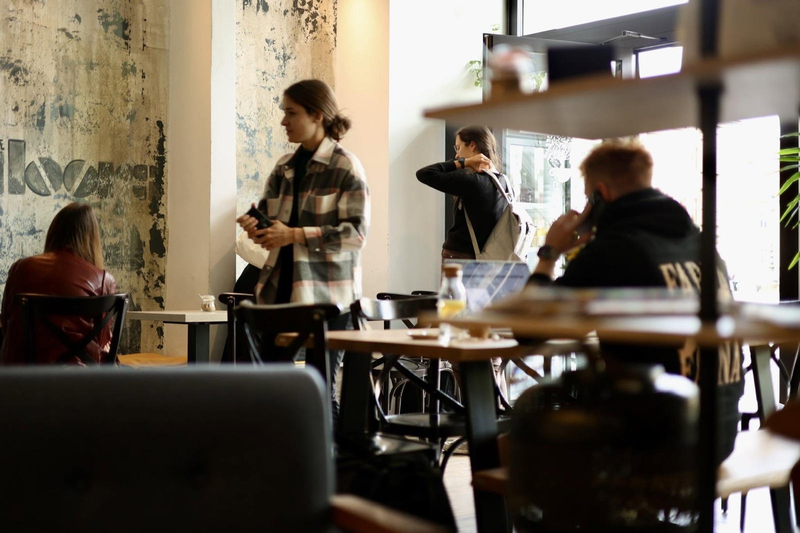 Interiér Coffee Park — dřevěné stoly, rostliny a denní světlo