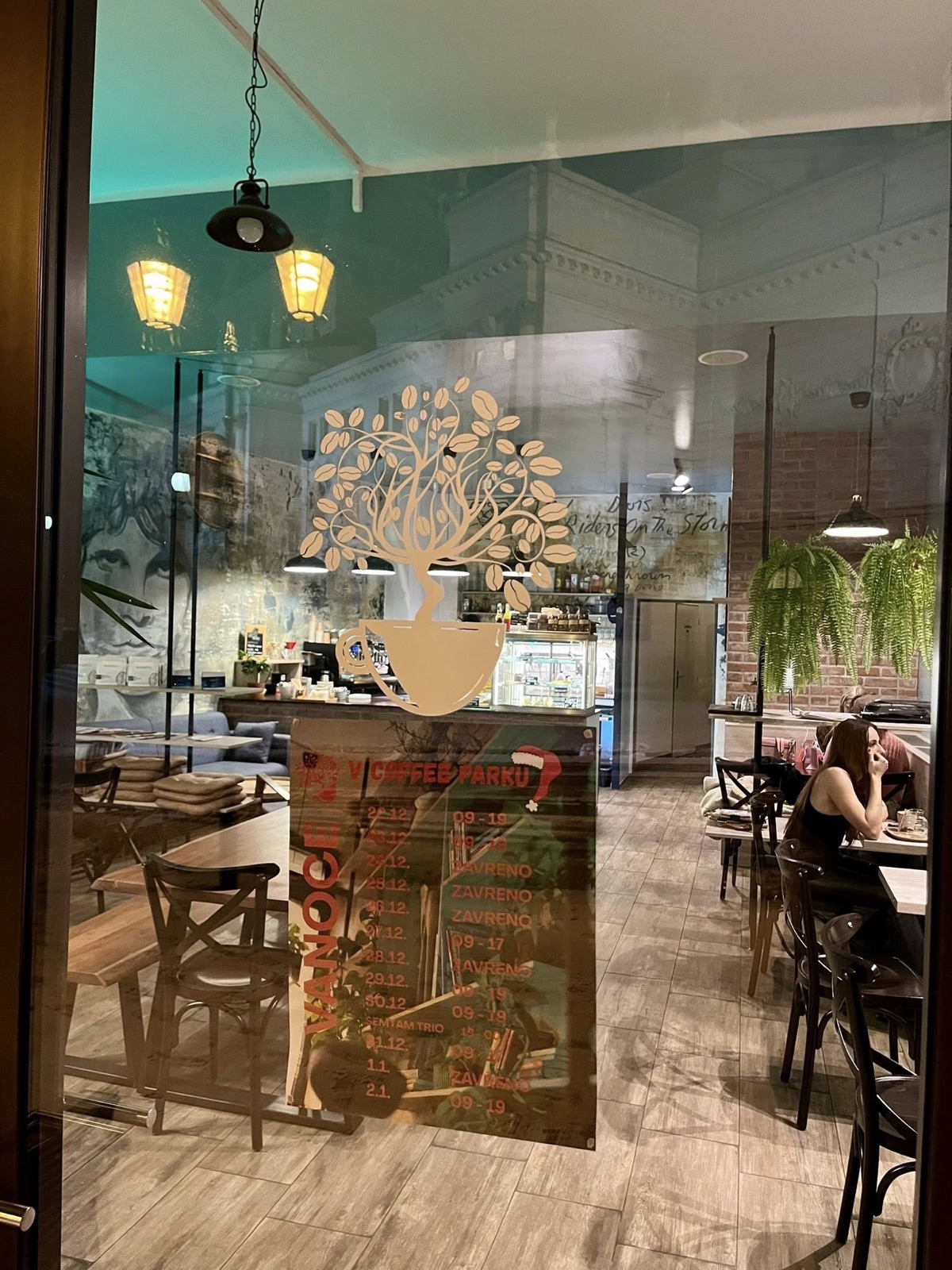 Útulný interiér kavárny Coffee Park plný rostlin za denního světla